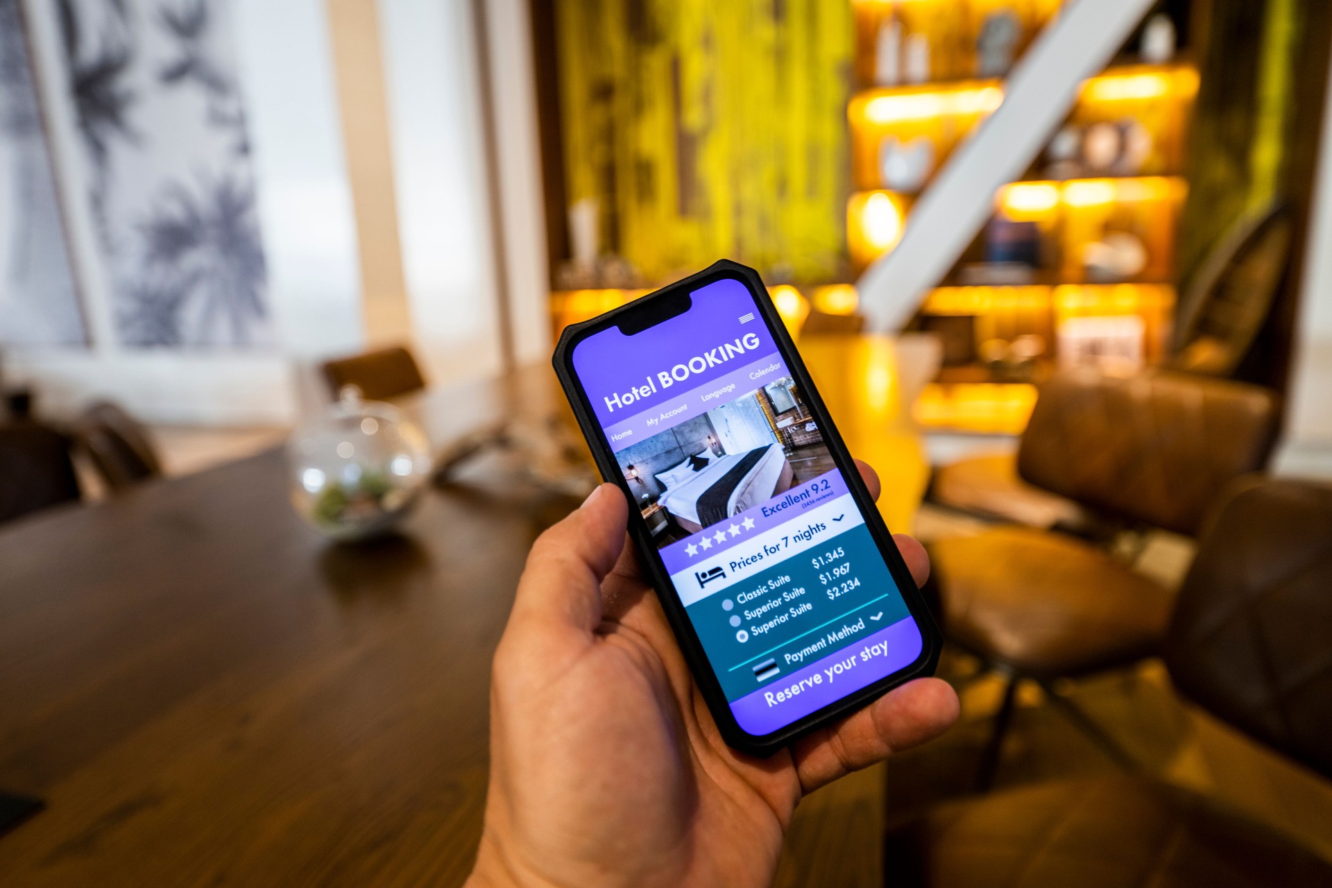 Booking app seen on a smart phone screen in a hotel lobby.