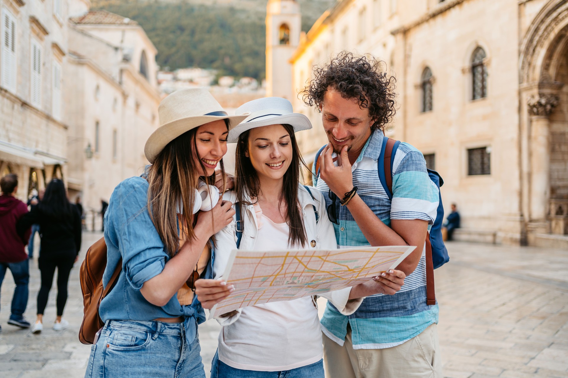 Three Young Friends Reading A Map On The Street In Dubrovnik